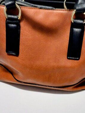 Brown purse with black handles, 3 interior sections with tassel 12X10X5